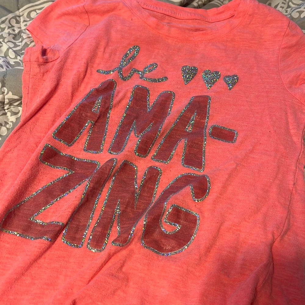 Pink short sleeve shirt says be amazing
